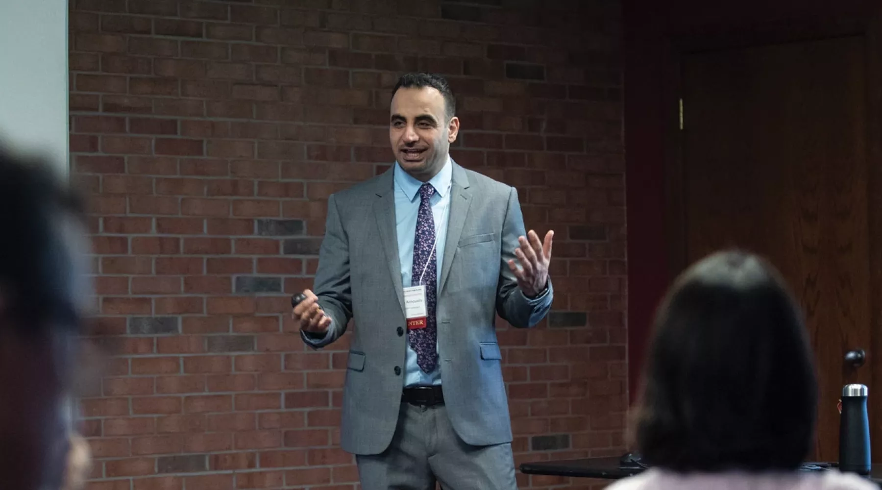 Man in grey suit speaking to an audience