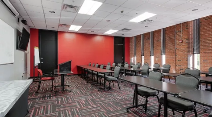 Class room with red wall and rows of tables and chairs