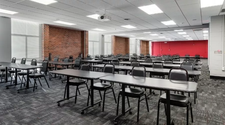 Large classroom with multiple rows of tables and chairs