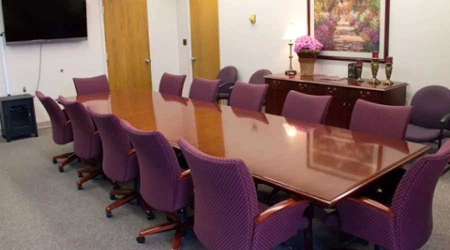 Meeting room with television and large conference table and chairs