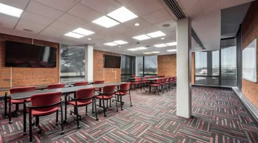 Classroom with televisions and multiple rows of tables and chairs