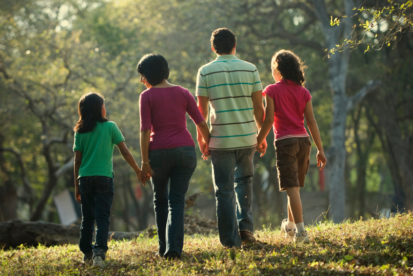 Mother and Father with two children walking.