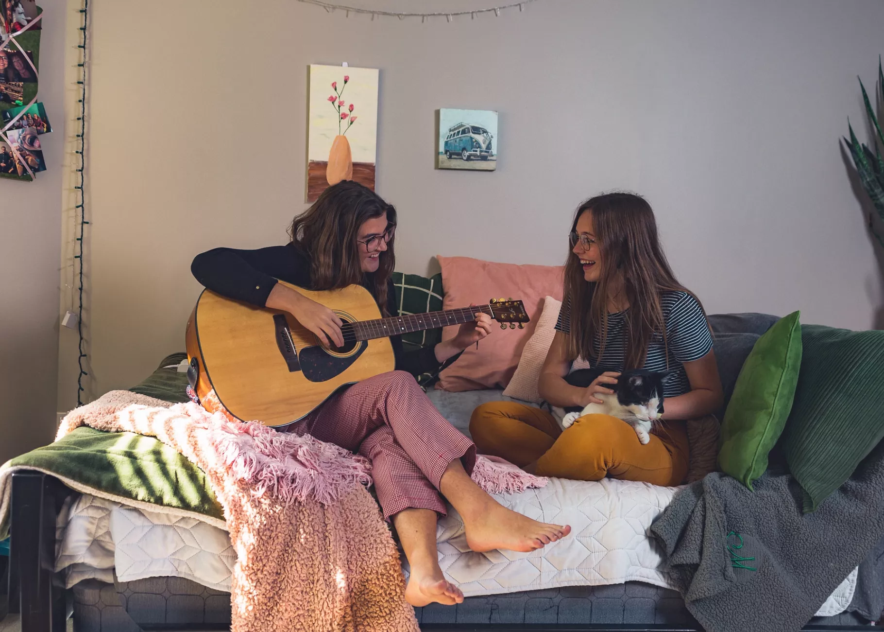 Music therapy majors Caroline Rushing and Mackenzie Aldridge entertain each other in the Rose Anna Hughes Home room they share with cat Louie.