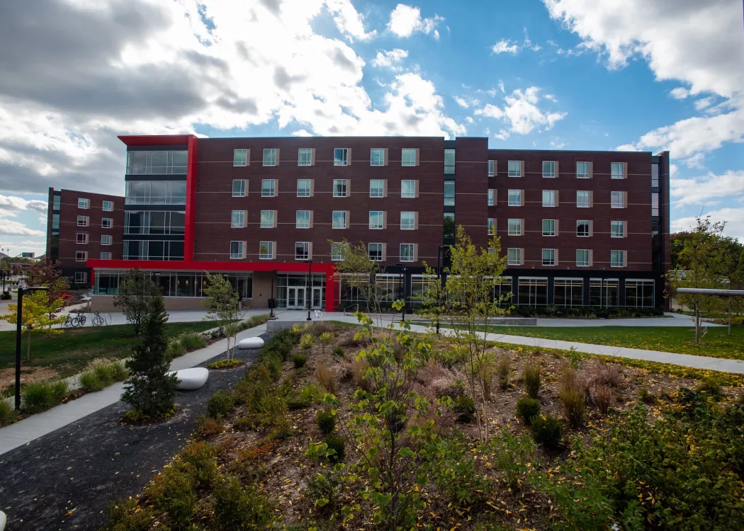 Full view of front of  Belknap Village North with greenery and sidewalks leading to it.