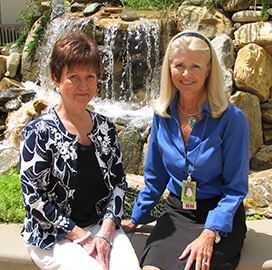 2 ladies in front of a waterfall