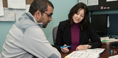 Office of Nursing Research faculty with student reviewing a document at a desk.