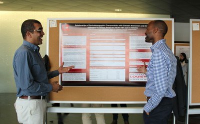 students pointing to a research poster