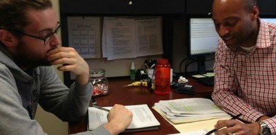 Office of Nursing Research faculty with student reviewing a document at a desk.