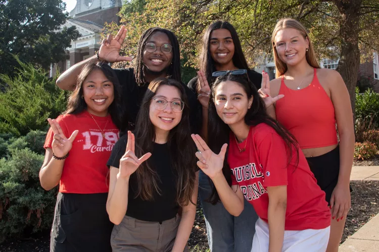 UofL Students posing and throwing up an "L"