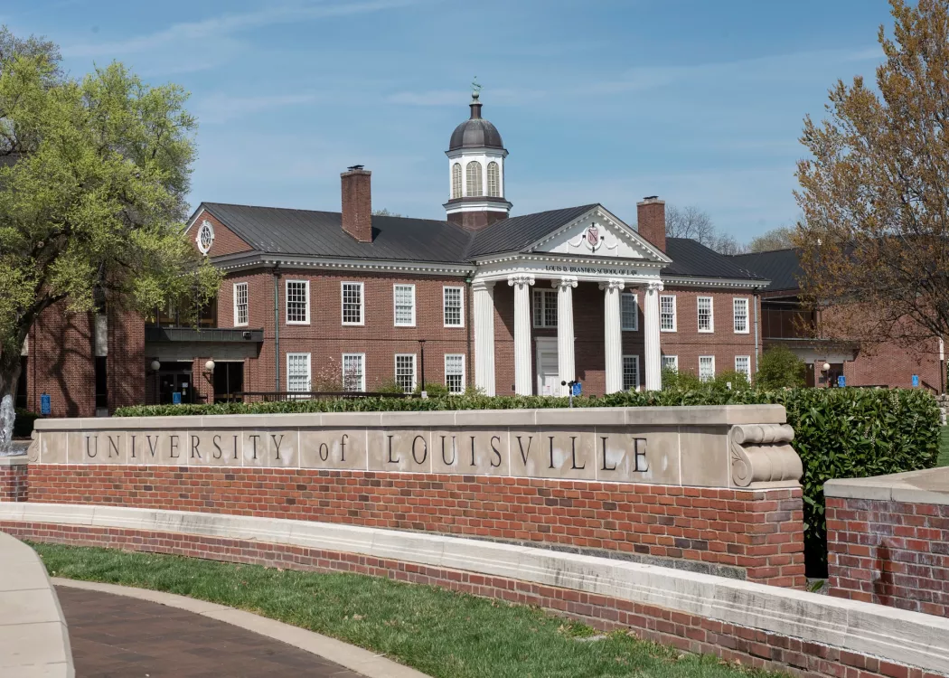 Louis D. Brandeis School of Law building in the background with the main University of Louisville entrance sign on 3rd Street.