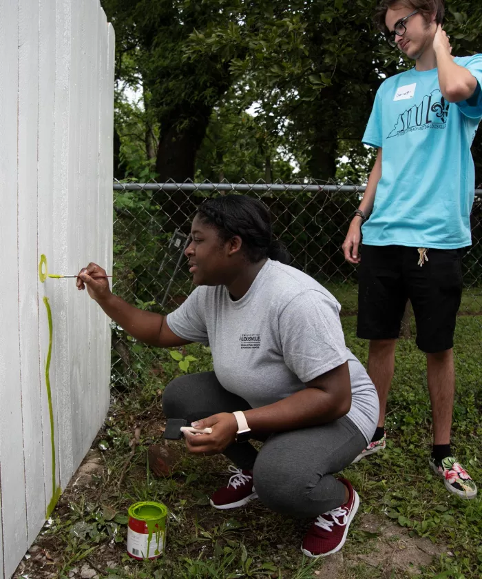 Students paint a fence with SOUL